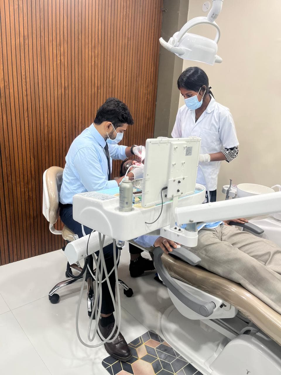 Dentist and assistant providing chairside care at META DENTAL