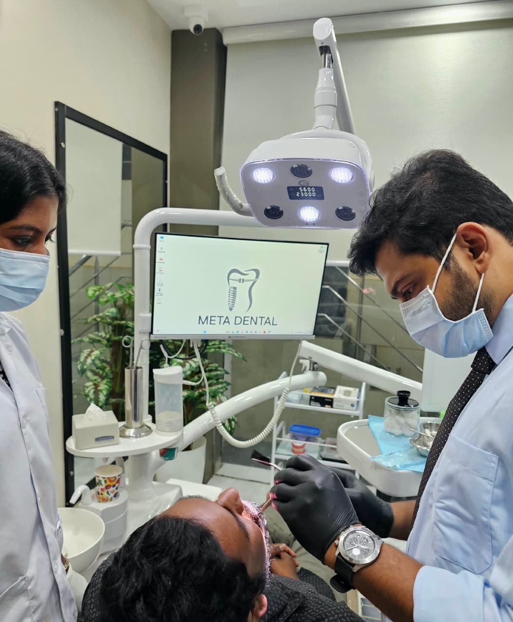 Dentist and assistant working beside the META DENTAL monitor